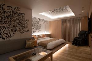 a bedroom with a bed and a couch and a table at HOTEL MYTH-WA -ホテル マイス ワ- adult only in Wakayama