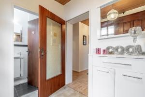 - une cuisine avec des placards blancs et une porte en bois dans l'établissement Private House, à Hanovre