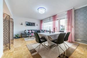 een woonkamer met een tafel en stoelen en een bank bij Private House in Hannover