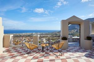 balcón con mesa y sillas y vistas al océano en Nano Suites, en Éxo Goniá