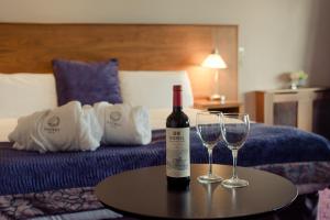 a bottle of wine and two glasses on a table in a hotel room at Osprey Hotel in Naas