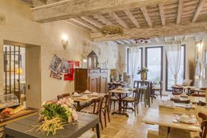 a dining room with tables and chairs and windows at Hotel Boquier in Avignon