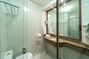 a bathroom with a glass shower and a toilet at Hotel Laghetto Viale in Gramado