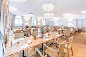 une salle à manger avec des tables, des chaises et des lustres dans l'établissement Hotel Weissenstein, à Oberdorf