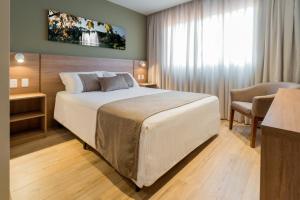 - une chambre avec un grand lit dans l'établissement Hotel Laghetto Pedras Altas, à Gramado