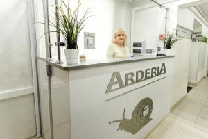 una mujer está de pie detrás de un mostrador en una farmacia en Гостиница Arderia, en Ufa
