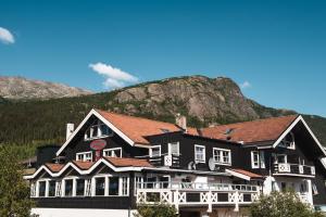 a large black building with a mountain in the background at Hemsedal Cafe Skiers Lodge in Hemsedal