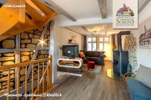 a living room with a couch and a tv and a staircase at Apartments Unter Dem Schloß in Quedlinburg