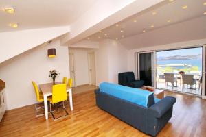 a living room with a blue couch and a table with yellow chairs at Apartments Kula in Janjina +26 photos