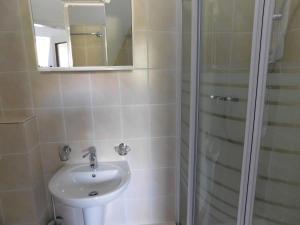 La salle de bains est pourvue d'un lavabo et d'une douche avec un miroir. dans l'établissement Vila Arnau, à Hostinné