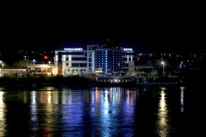 a city lit up at night with a body of water at Parliament Palace Hotel in Khujand