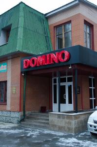 a building with a red domining sign on it at Гостиница Домино in Tyumen