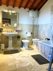 ein Badezimmer mit zwei Waschbecken, einer Badewanne und einem WC in der Unterkunft Borgo San Gusmè in San Gusmè