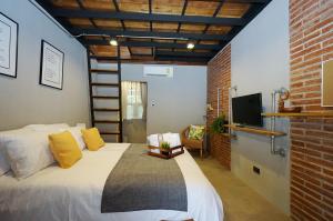 a bedroom with a large bed and a tv at Yellow Pillow village in Chiang Mai
