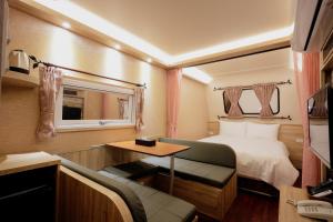 1 dormitorio con cama, mesa y sofá en Ouxiang Manor Hotel en Yuanlin