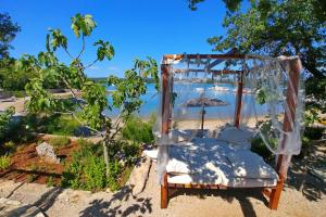 an old chair sitting on the beach with an umbrella at Krk Mobile Homes in Klimno