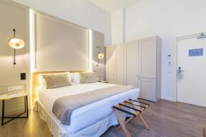 a bedroom with a large bed and a chair at ICON Rosetó in Palma de Mallorca