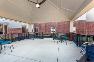 a patio with chairs and tables and a brick building at Candlewood Suites Bethlehem South by IHG in Bethlehem