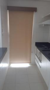 a white kitchen with a stove and a refrigerator at Apartamento Veredas in Rio Quente