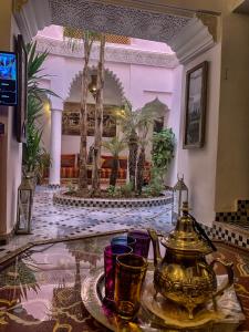Riad Abaka hotel & boutique في مراكش: لوبي الفندق مع وجود غلاية الشاي على الطاولة