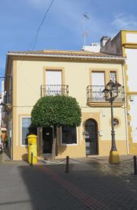 a yellow building with a tree in front of it at Casa Rural Vista Bonita in Almodóvar del Río