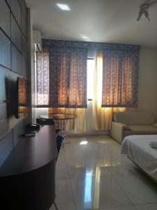um quarto com uma cama, um sofá e uma mesa em Águas Palace Hotel em Petrolina