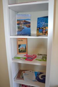 une étagère remplie de livres et de brochures dans l'établissement La casa del cocchiere, à Palerme