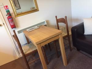 No. 5 Smith Cottages في Langport: طاولة وكراسي خشبية صغيرة في الغرفة