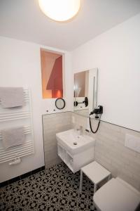 a white bathroom with a sink and a mirror at Design Hotel Sophie´s in Norderney