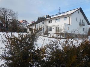 a white house with snow in front of it at Ferienwohnung Casa MIA in Spiegelau