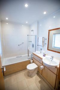 a bathroom with a toilet and a tub and a sink at Mallory Court Country House Hotel & Spa in Leamington Spa