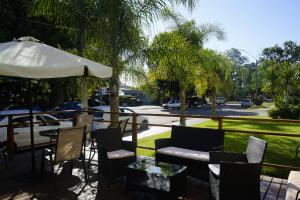 a patio with a table and chairs and an umbrella at Hotel Argentina in Atlántida