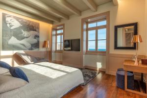 a bedroom with a large bed and a television at Luxury Barreirinha House old town by HR MADEIRA in Funchal