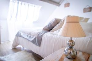 ein Schlafzimmer mit einem Bett und einem Tisch mit einer Lampe in der Unterkunft Champagne cocoon in Épernay