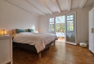 a bedroom with a bed and a large window at Ferienwohnung im Fachwerkhof 'Haus in Bewegung' in Seelscheid