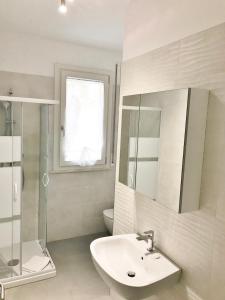 uma casa de banho com um lavatório, um chuveiro e um WC. em Alghero CHARMING APARTMENTS DOWNTOWN em Alghero