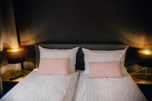 a bedroom with two beds with pink and white pillows at JBHotels - Apartament Deluxe in Szczecin