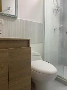 La salle de bains est pourvue de toilettes et d'une douche en verre. dans l'établissement HOTEL BELEN-La Flora- Cali Valle del Cauca, à Cali