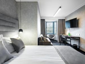 a hotel room with a bed and a desk at Hotel Logos Kraków in Krakow