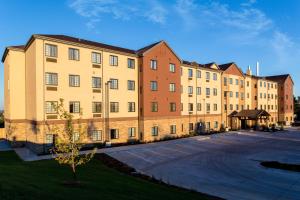 a large brick building with a parking lot at Staybridge Suites Omaha West by IHG in Omaha