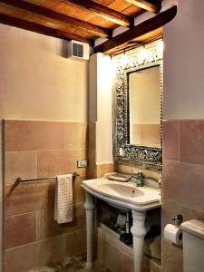 W łazience znajduje się umywalka i lustro. w obiekcie Borgo San Gusmè w mieście San Gusmè
