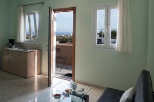 una sala de estar con una puerta que da a un balcón en Moonlight Apartments, en Fira