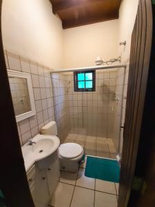 y baño con aseo, lavabo y ducha. en Casa Pomar do Aconchego, en Paraty