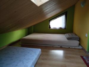 two beds in a small room with a window at podkornutami in Sękowa