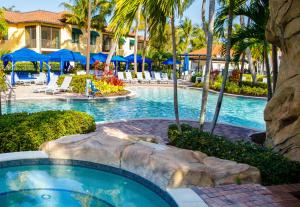 a pool at a resort with chairs and palm trees at Naples Bay Resort and Marina in Naples