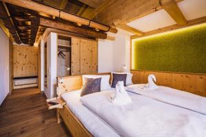2 camas en una habitación con una pared verde en Hotel Garni Panorama Guggenbichl, en Kaprun