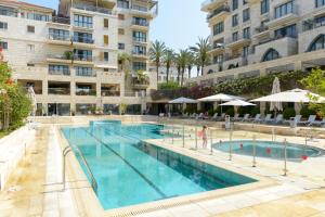 a large swimming pool in front of a building at Andromeda Hill Amazing Suite in Tel Aviv