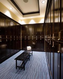 a locker room with a bench and wooden cabinets at Naples Bay Resort and Marina in Naples