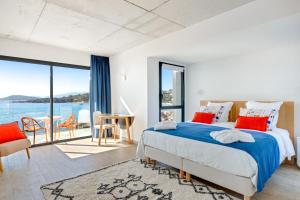 a bedroom with a bed and a view of the water at Hotel le Jardin d'Emile in Porticcio +23 photos