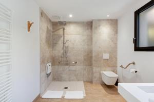 a bathroom with a shower and a toilet and a sink at Hotel le Jardin d'Emile in Porticcio